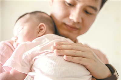 賴永新化身溫柔奶爸，抱著剛出生小女兒哄她入睡。