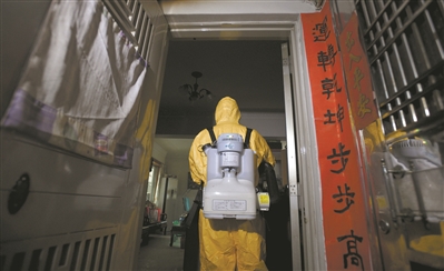 工作人員背著重達15公斤以上的機器，對確診病例屋里物品進行細致消毒。